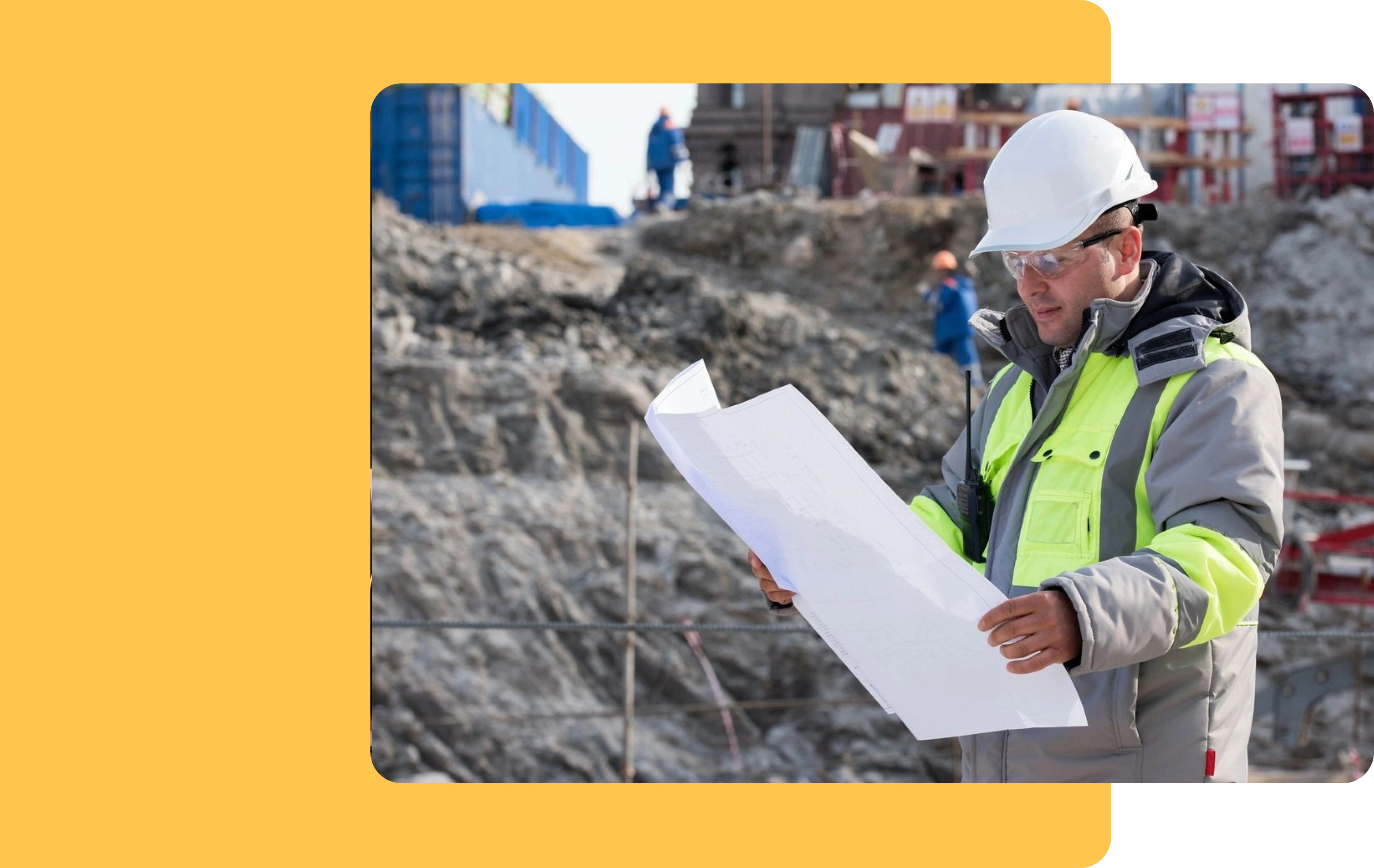 A man in safety gear holding papers on top of a hill.