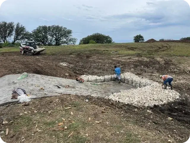 A group of people standing on top of a dirt field.