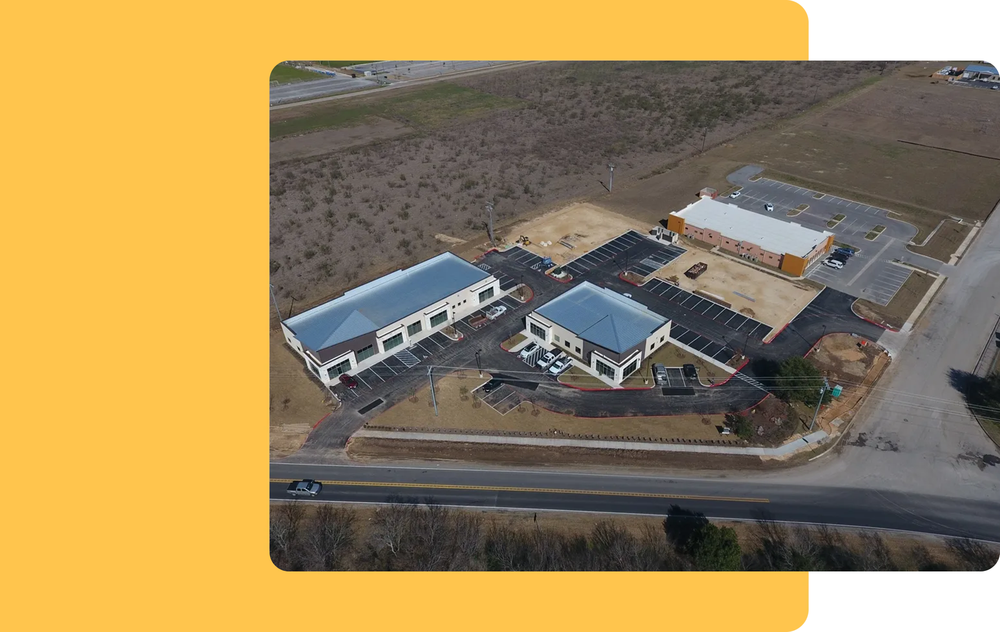 An aerial view of a building with a road in the background.